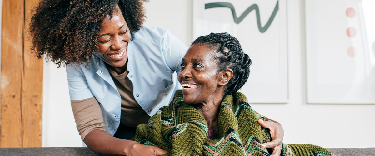 Nurse putting a blanket around a senior woman