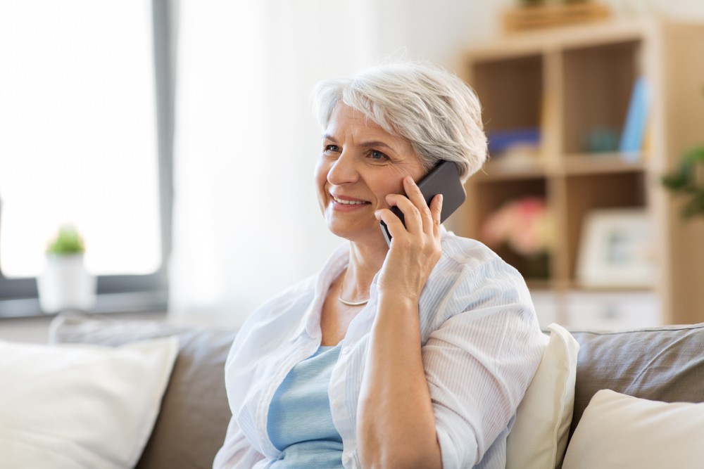 happy senior woman on her phone while at home