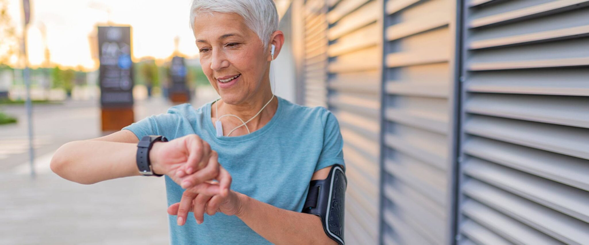 senior lady on a jog looks down at her smart watch