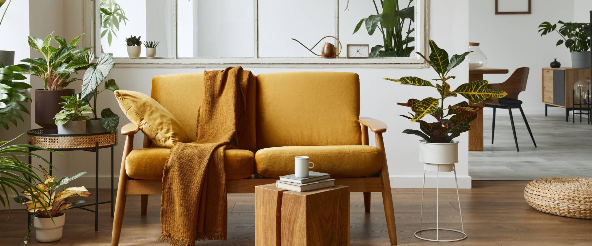 small loveseat couch surrounded by plants