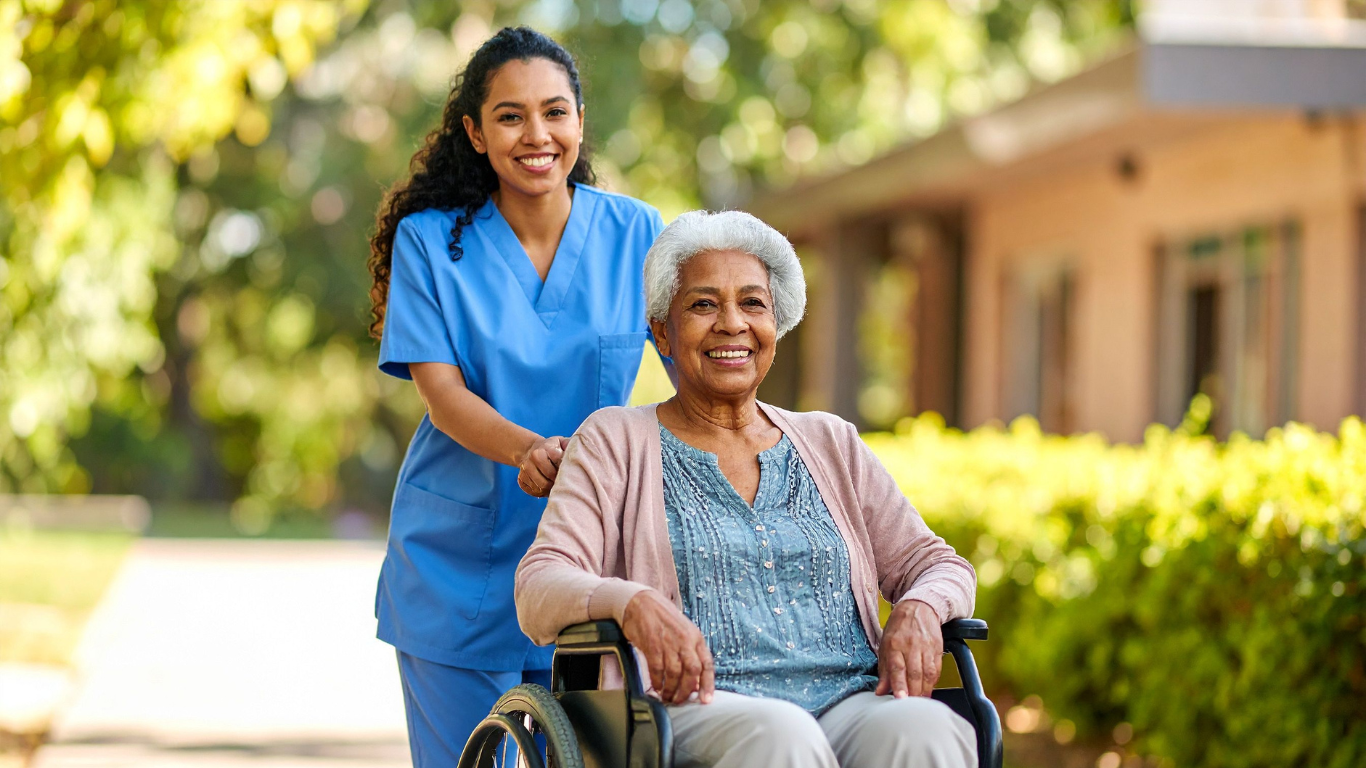 Nurse walking with senior woman in wheelchair