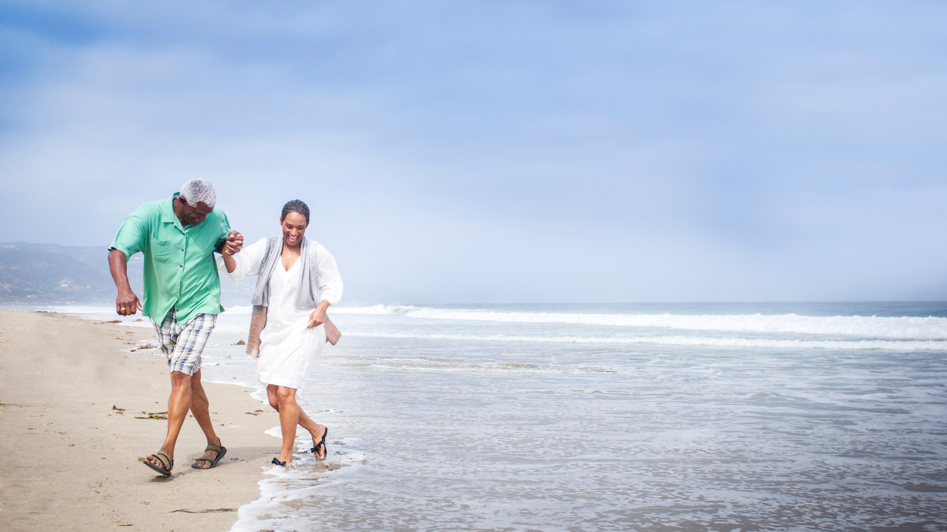 Senior couple walking along beach