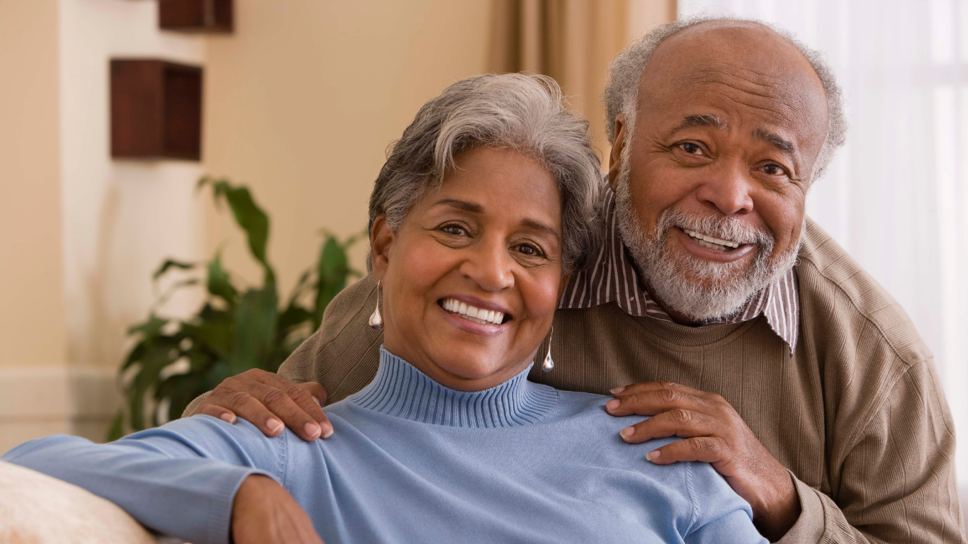 Senior couple smiling together on a couch