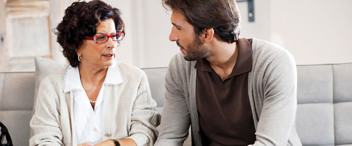 Man speaks with woman about moving senior parents into assisted living.