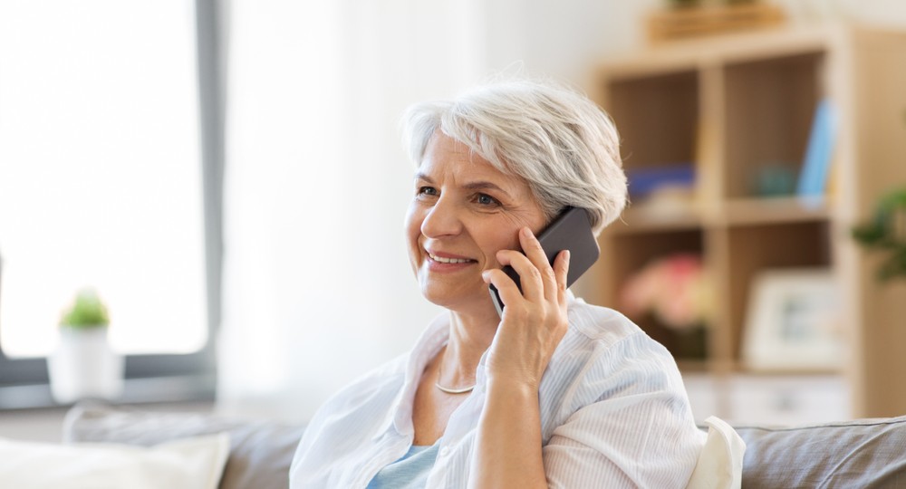 happy senior woman on her phone while at home