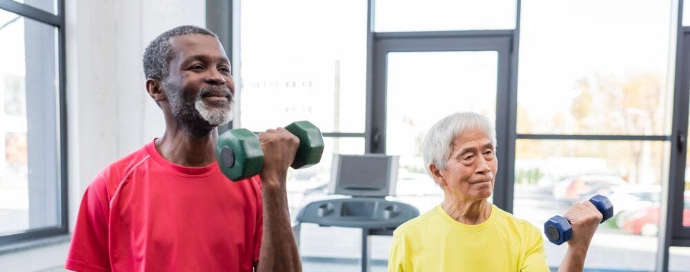 two senior men lifting weights