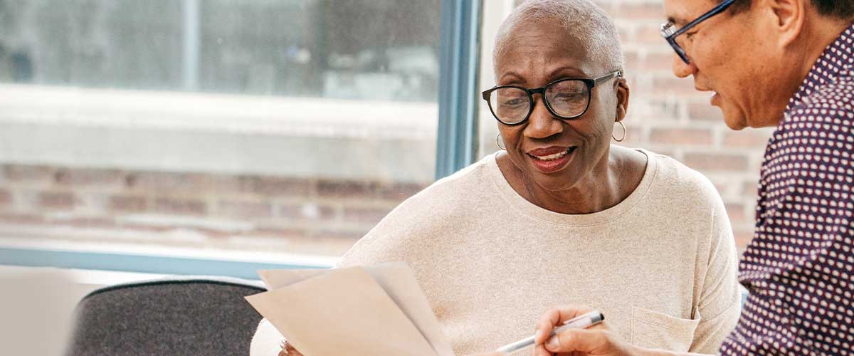 Senior woman reading paperwork in her senior living apartment