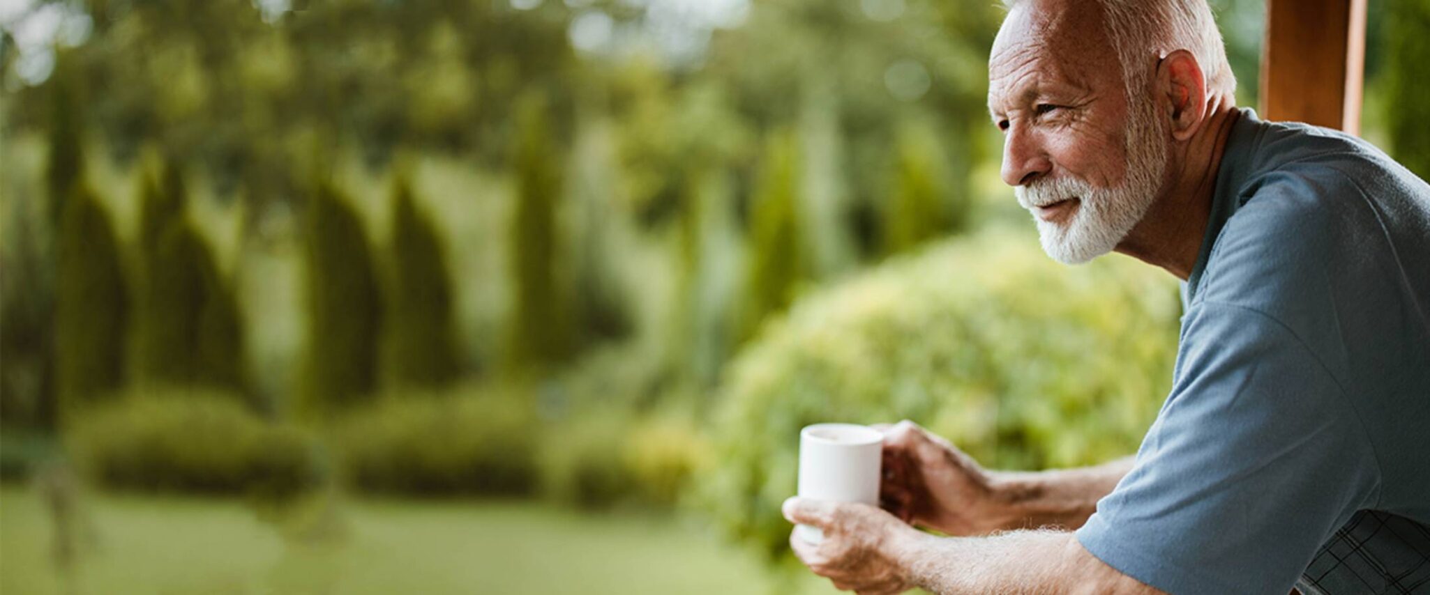 senior man practices mindfulness and meditation on porch with coffee