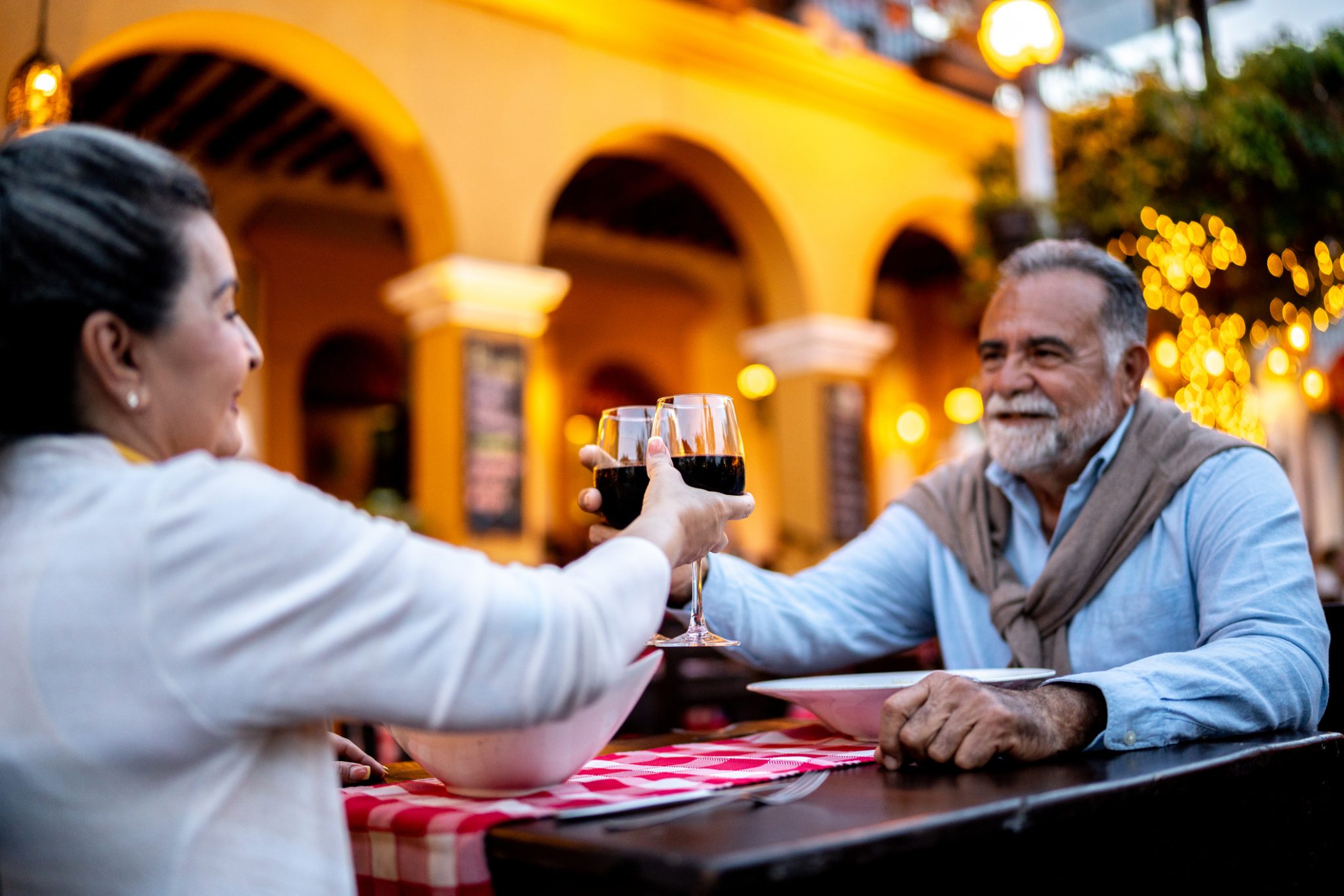 Senior couple toasting with a glass of wine during outdoor dinner